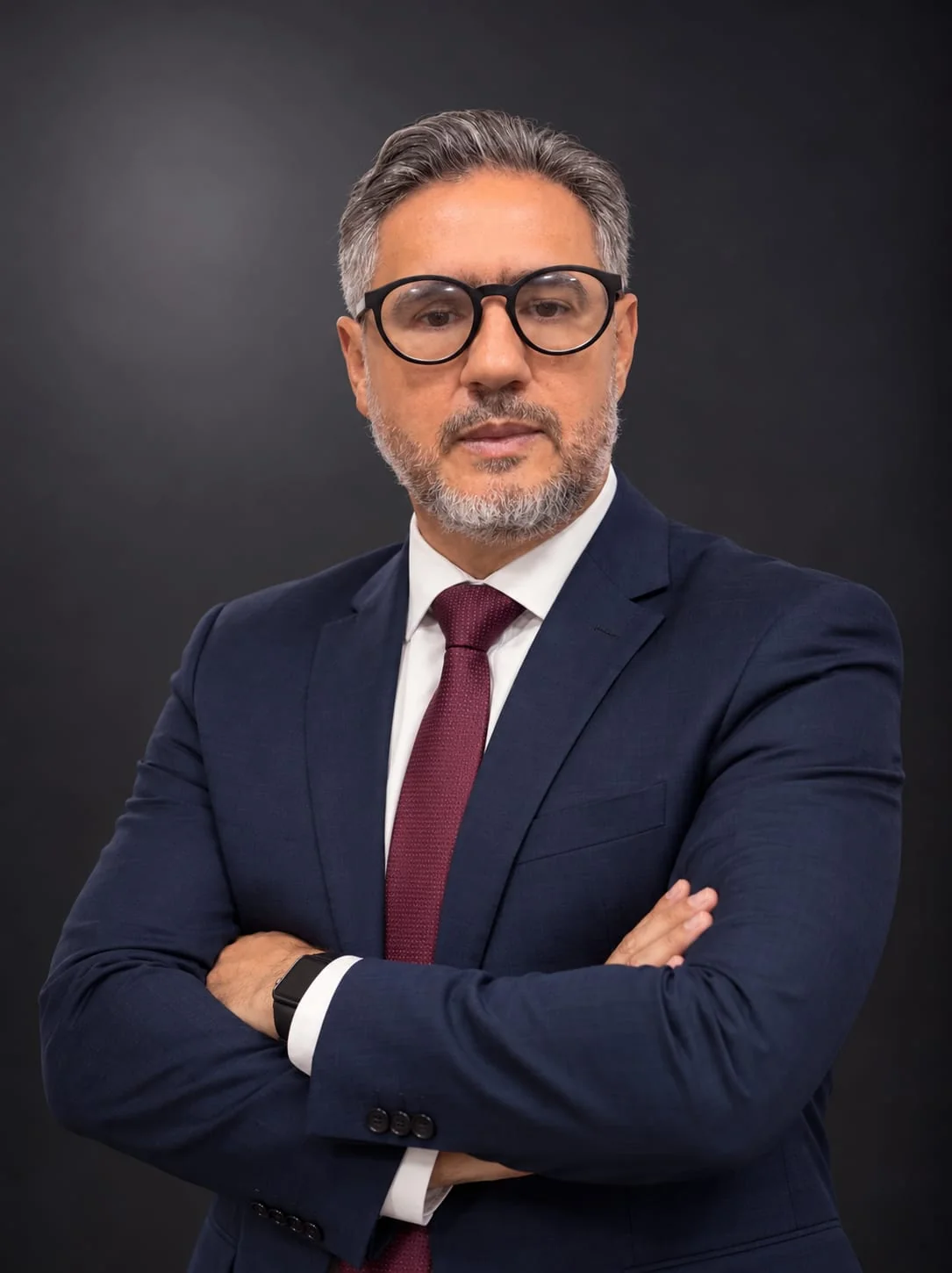 Dr. José Maria de Souza Rodrigues, à esquerda, com óculos, terno azul, gravata vinho e braços cruzados